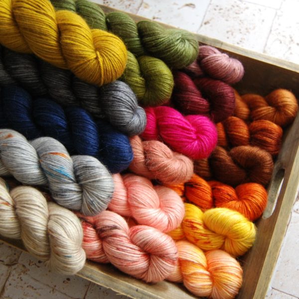 Skeins of LO(U)VE ASC DK yarn grouped on a table